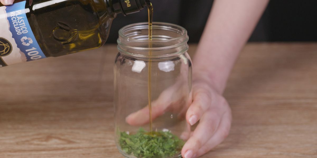 Verter aceite de oliva virgen extra en vinagreta mediterránea