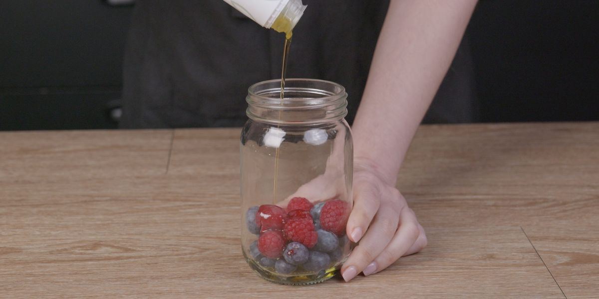 Verter Aceite de oliva virgen extra en Vinagreta de frutos rojos