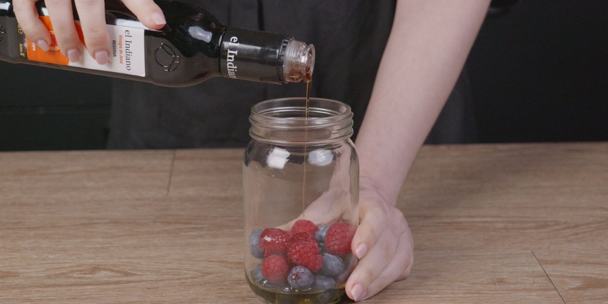 Añadir vinagre a Verter Aceite de oliva virgen extra en Vinagreta de frutos rojos