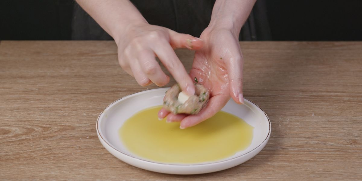 Introducir queso y cerrar albóndigas de pollo y espinacas