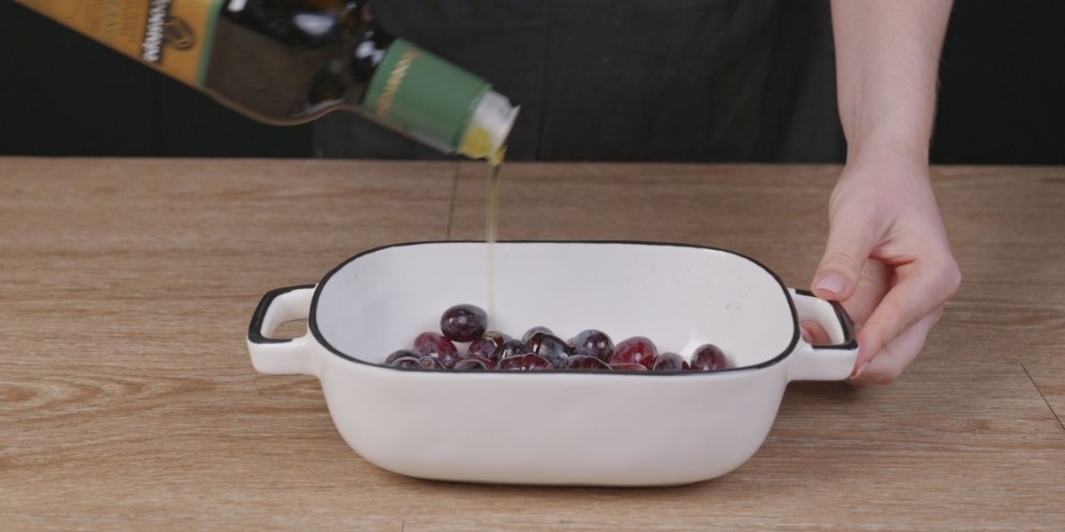 Verter aceite de oliva virgen extra en Aperitivo de uvas pasas