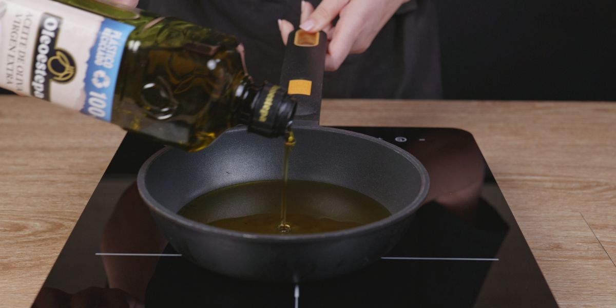 Verter aceite de oliva virgen extra a sartén para Crujientes de salmón