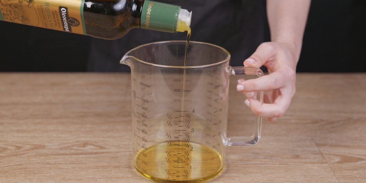 Echar aceite de oliva virgen extra en el vaso de la batidora para el tomate burrata