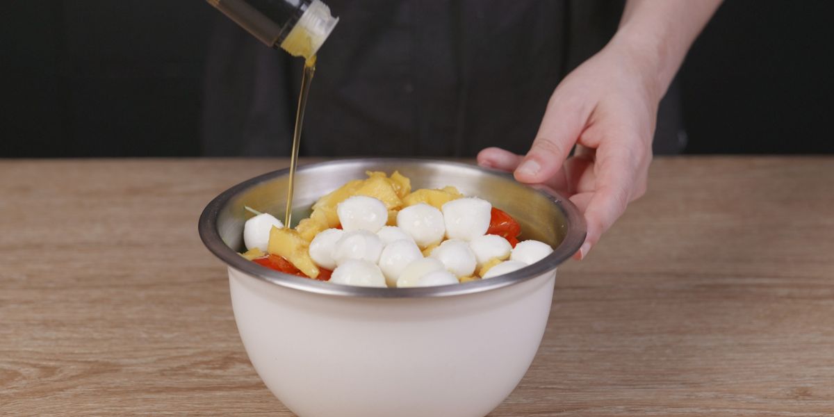 Echar aceite de oliva virgen extra a ensalada de tortelini