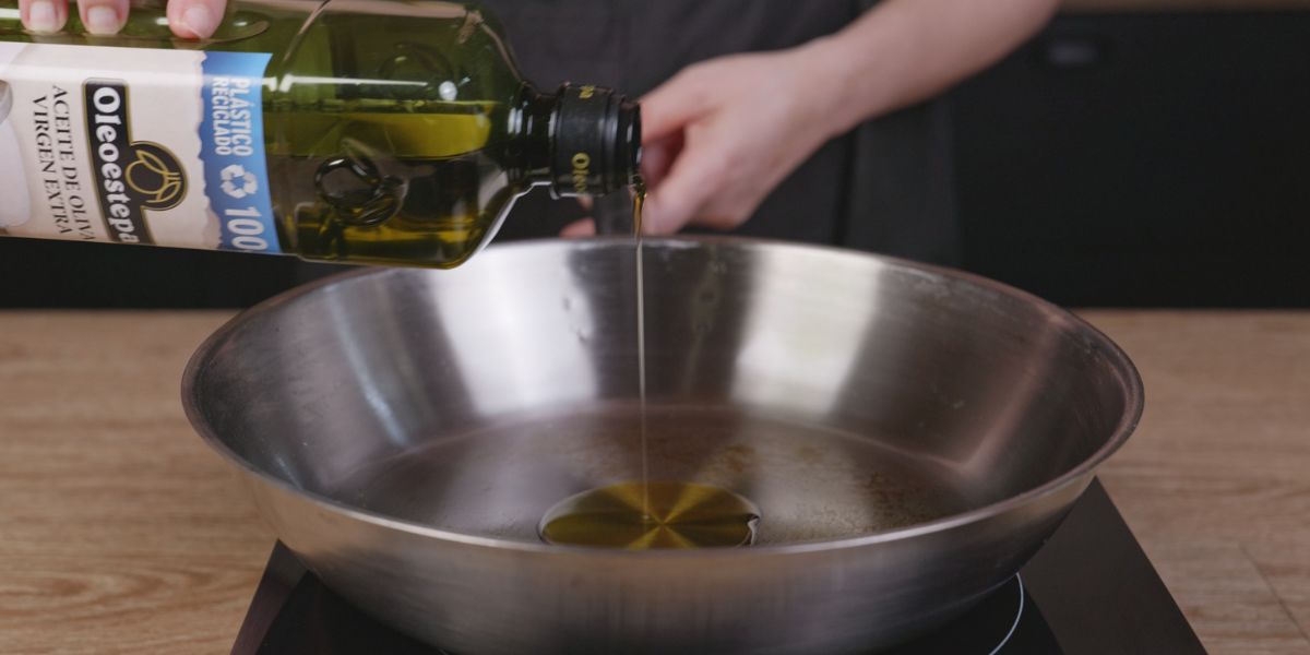 Echar aceite de oliva virgen extra para hacer Gambas y calabacín en salsa de curry 
