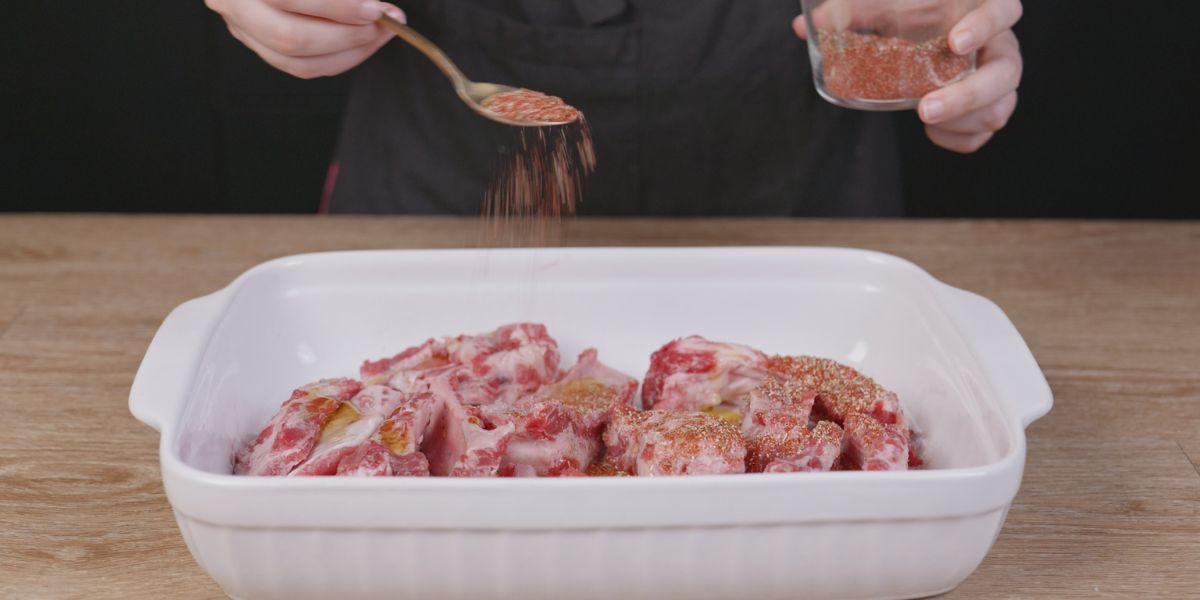 Espolvorear especias sobre costillas al cajún