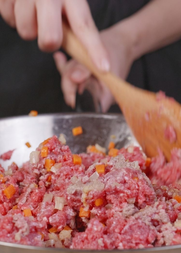 Incorporar carne y especias a salsa boloñesa