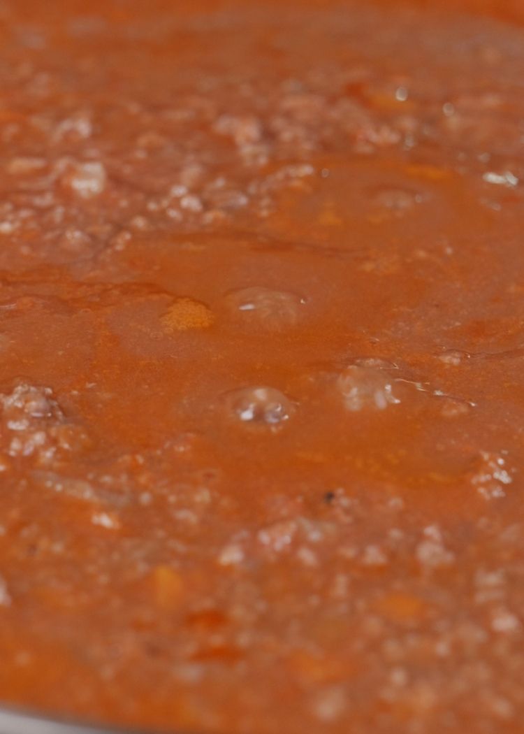 Echar agua y cocinar la salsa boloñesa