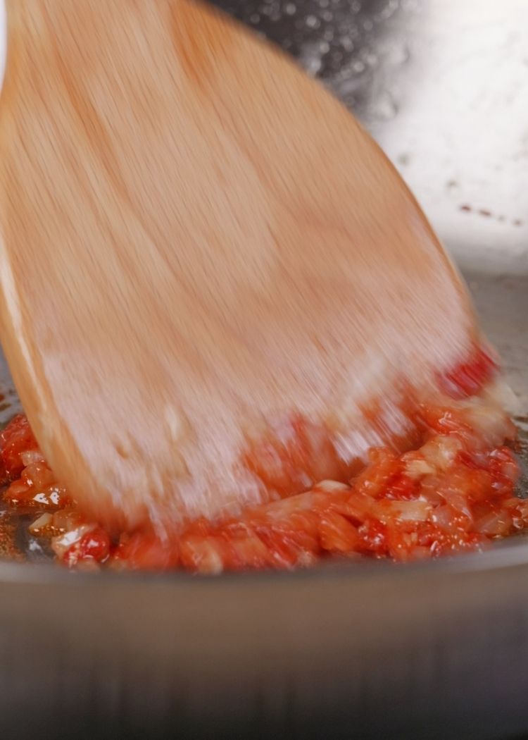 Sofreír cebolla, ajo y pasta de tomate en pollo al curry