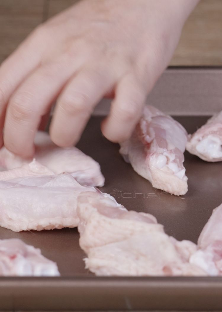 Colocar alitas de pollo en bandeja de horno