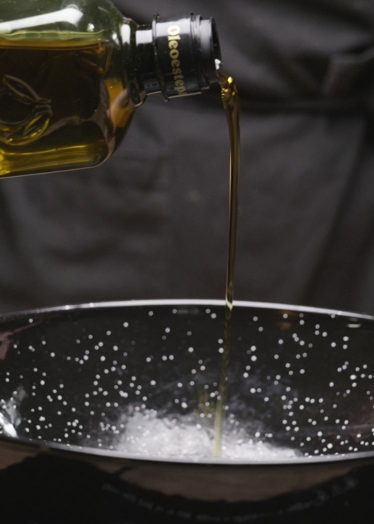 Echar aceite de oliva virgen extra para cocinar el Arroz con sobras de pollo en salsa 