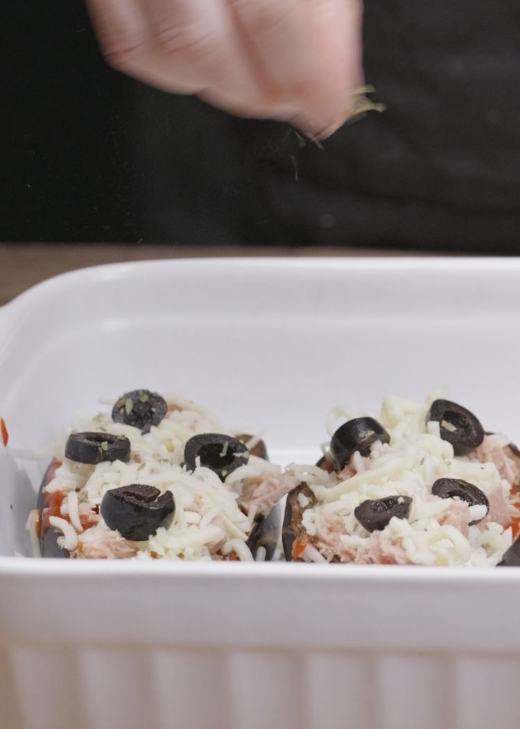Echar atún, queso y aceitunas a berenjenas rellenas