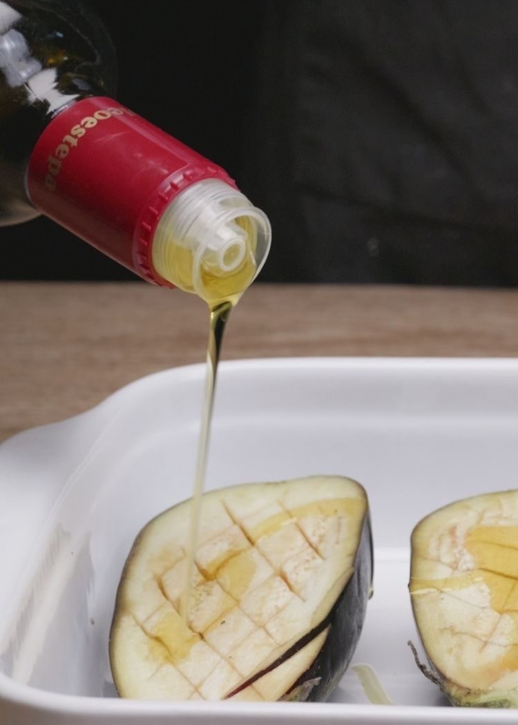 Echar aceite de oliva virgen extra a berenjenas rellenas