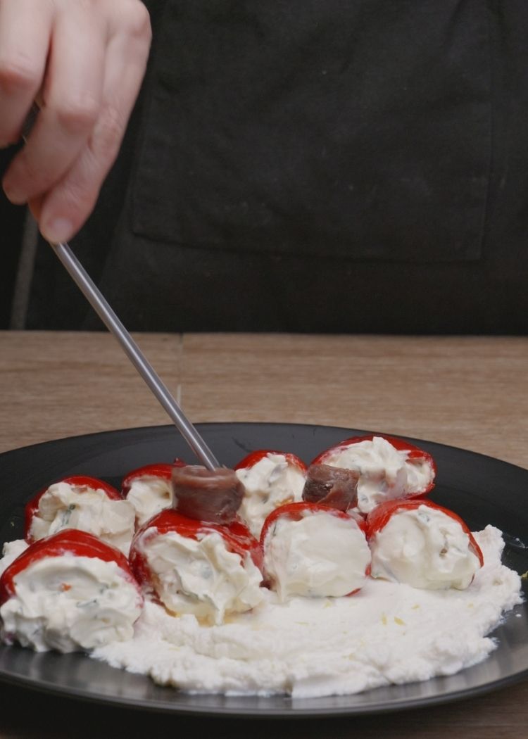 Colocar anchoas sobre pimientos del piquillo 