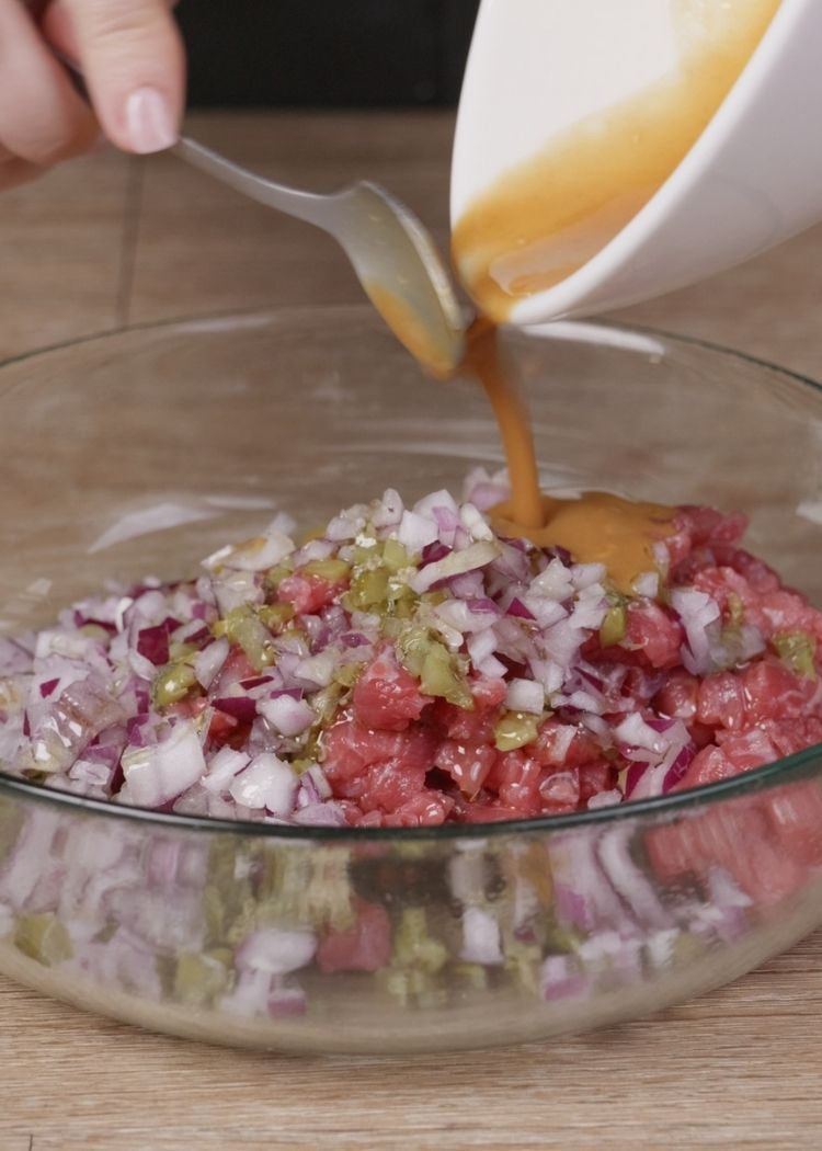 Verter salsa en la mezcla del Steak Tartar