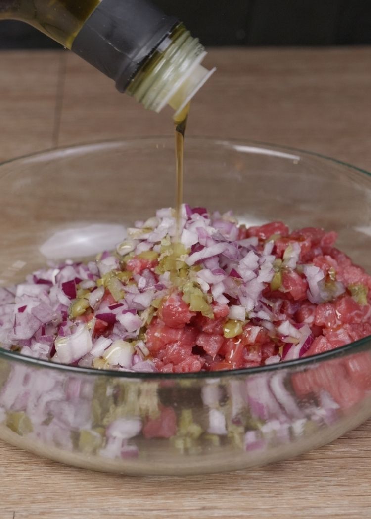 Echar aceite de oliva virgen extra a la mezcla para Steak Tartar
