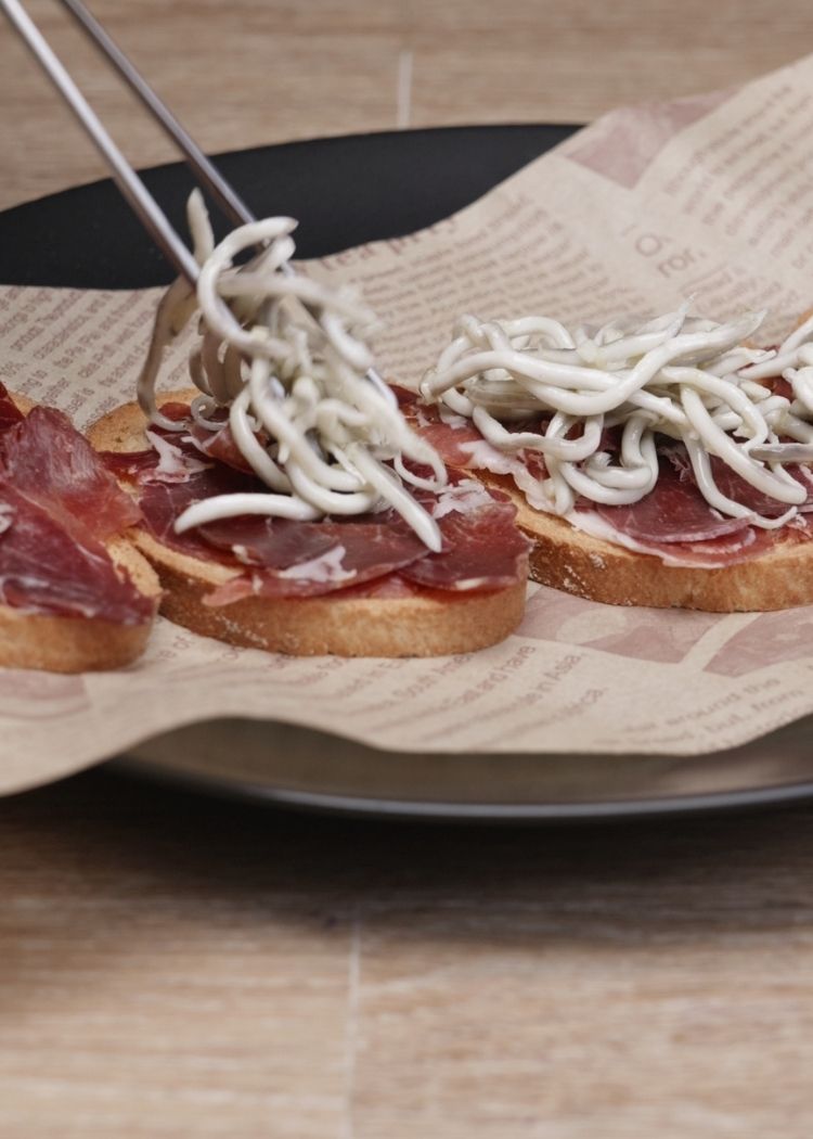 Colocar gulas y jamón sobre Tostas con jamón y gulas