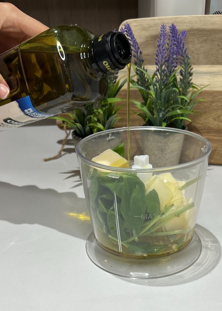 Echar aceite de oliva virgen extra para hacer pesto para Tostada de pesto y burrata
