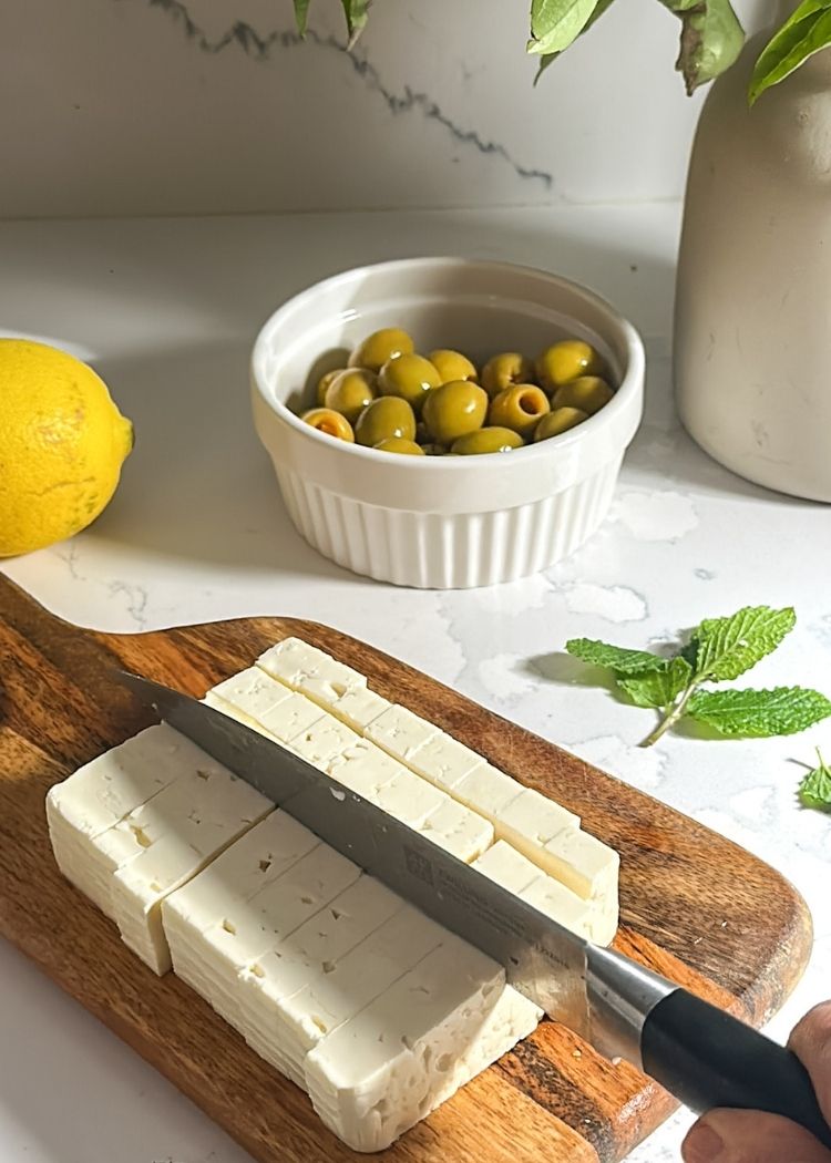 Cortar queso feta para aceitunas con queso feta al limón