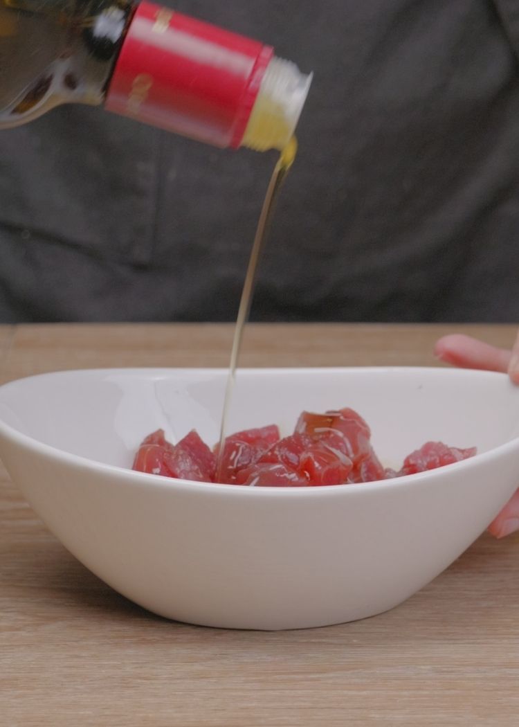 Añadir aceite de oliva virgen extra al atún rojo para canapés de endivias