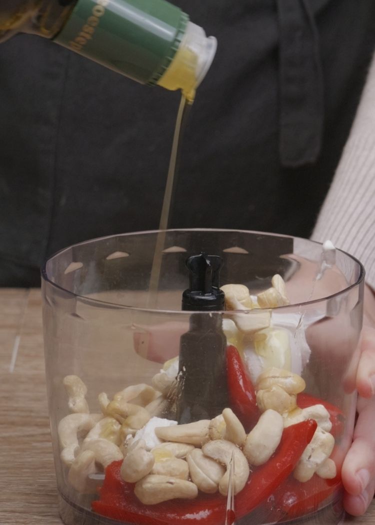 Añadir aceite de oliva virgen extra a crema de piquillos