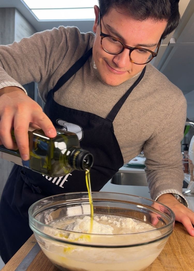 Añadir aceite de oliva virgen extra a la masa de la Focaccia con pesto de pistacho