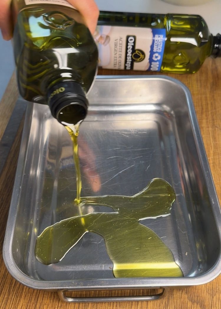 Poner aceite de oliva virgen extra en una bandeja para Focaccia con pesto de pistacho