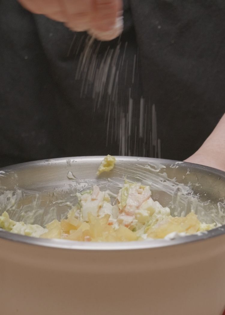 Añadir piña y sal a ensalada tropical