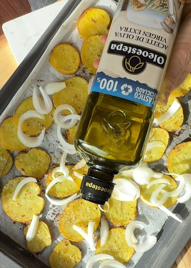 Añadir chalotas y aceite de oliva virgen extra para huevos rotos con patatas y chalotas al horno