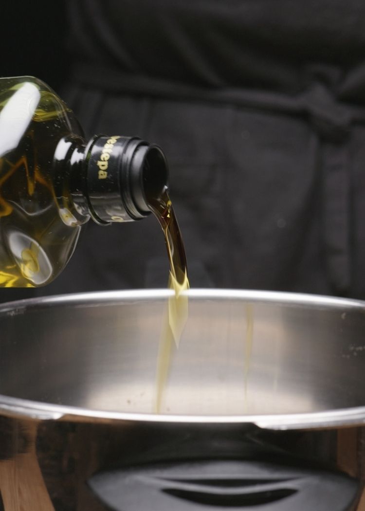 Echar aceite de oliva virgen extra a la olla para cocinar lentejas con verduras